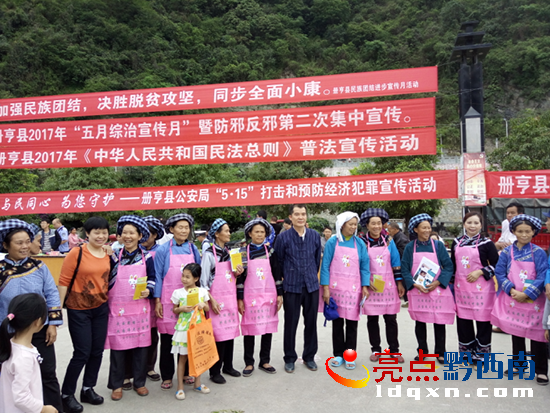 圖為宣傳活動現(xiàn)場群眾開心的戴起普法圍腰1.png