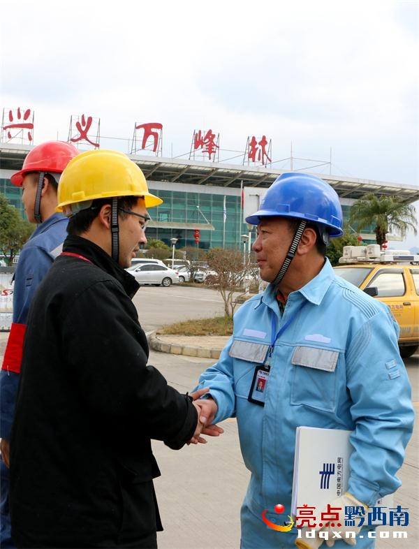 萬峰林機(jī)場工作人員緊握興義供電局城區(qū)分局“心意電”服務(wù)隊隊員的手，對他們的優(yōu)質(zhì)服務(wù)表示謝意（盧關(guān)文 攝）.JPG